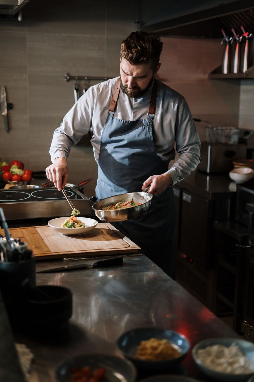 Chef plating artisanal dish in a minimalist open kitchen